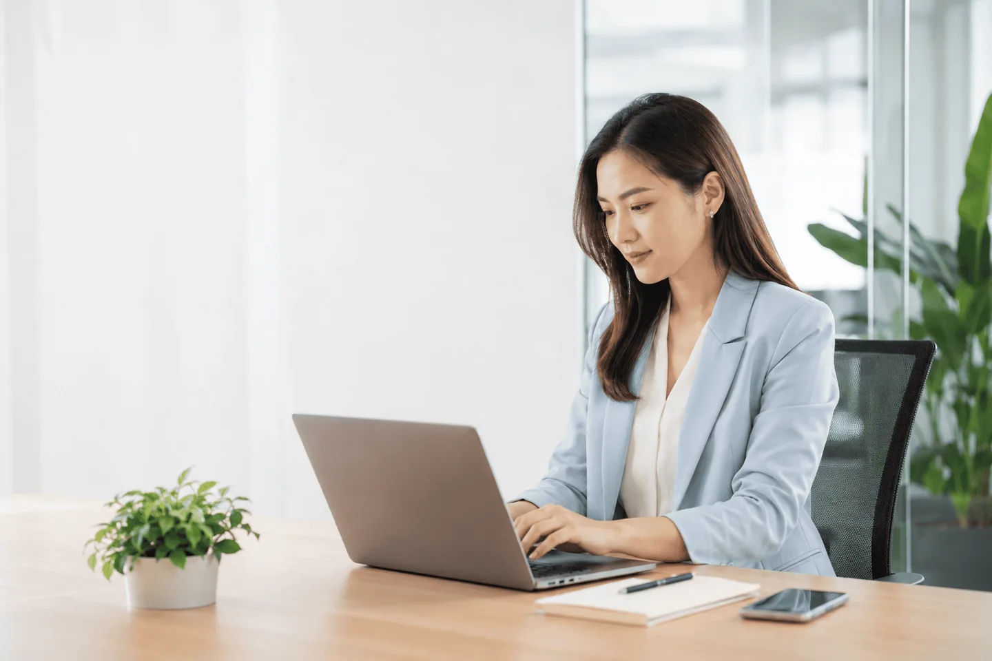 Người phụ nữ làm việc với laptop trong căn phòng sáng